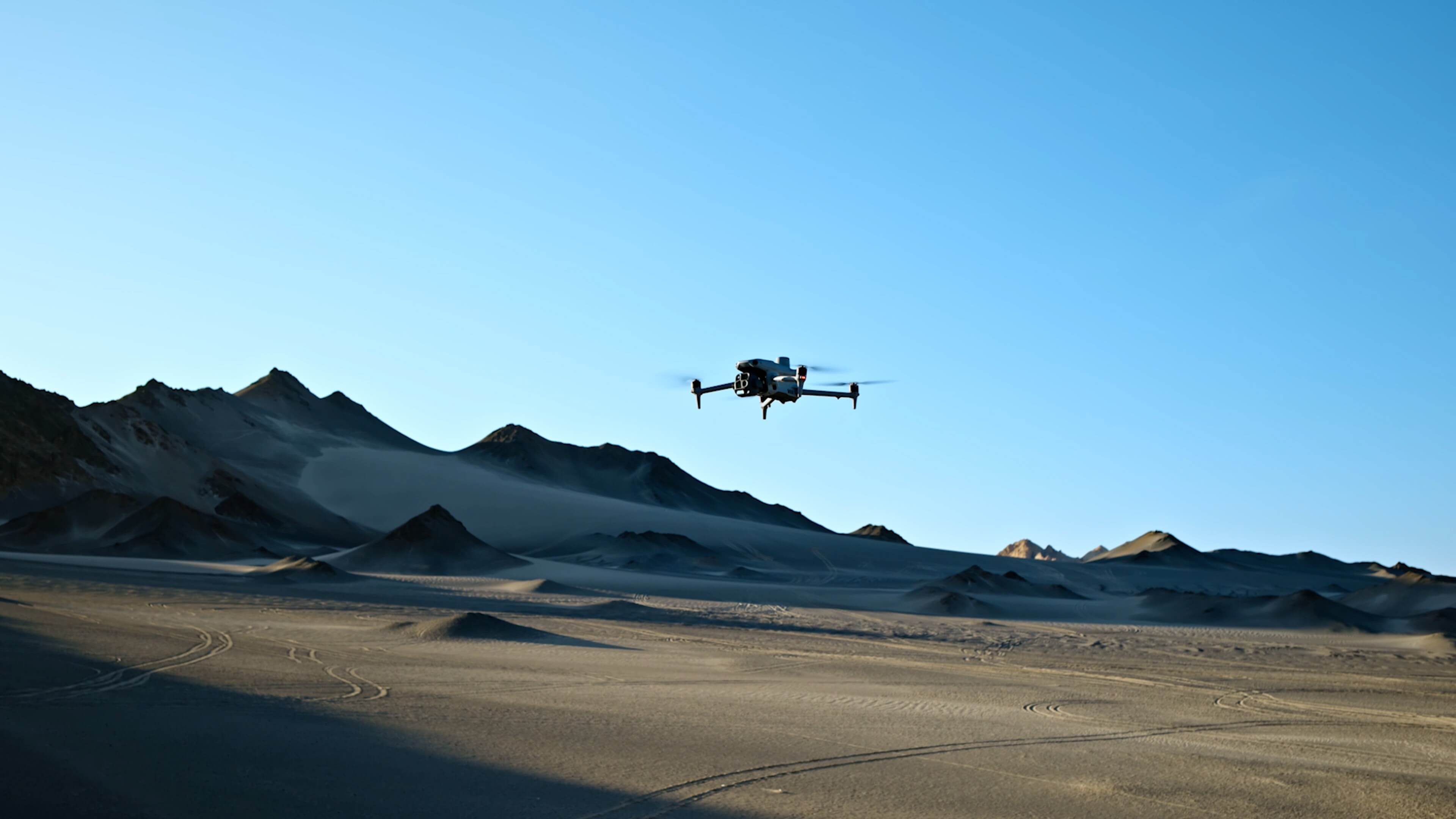 Vue large du DJI Matrice 4T en vol au-dessus d’un paysage montagneux — visuel DJI
